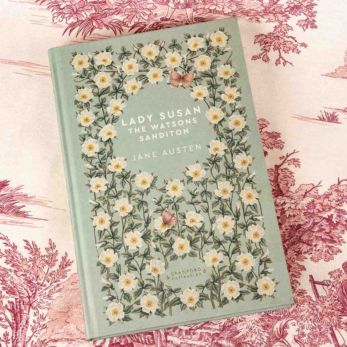 Front cover is washed green with cream flowers and red butterflies decorating the cover