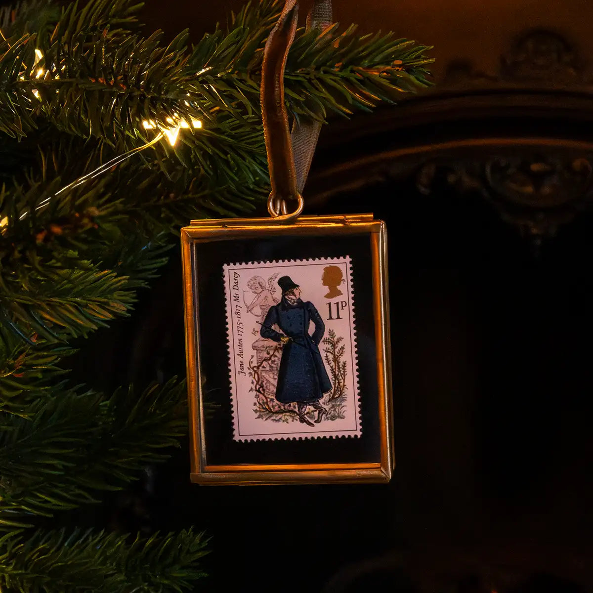 Christmas scene. Someone hanging the decoration on a Christmas tree. In background is a fire and there are fairy lights on the tree.