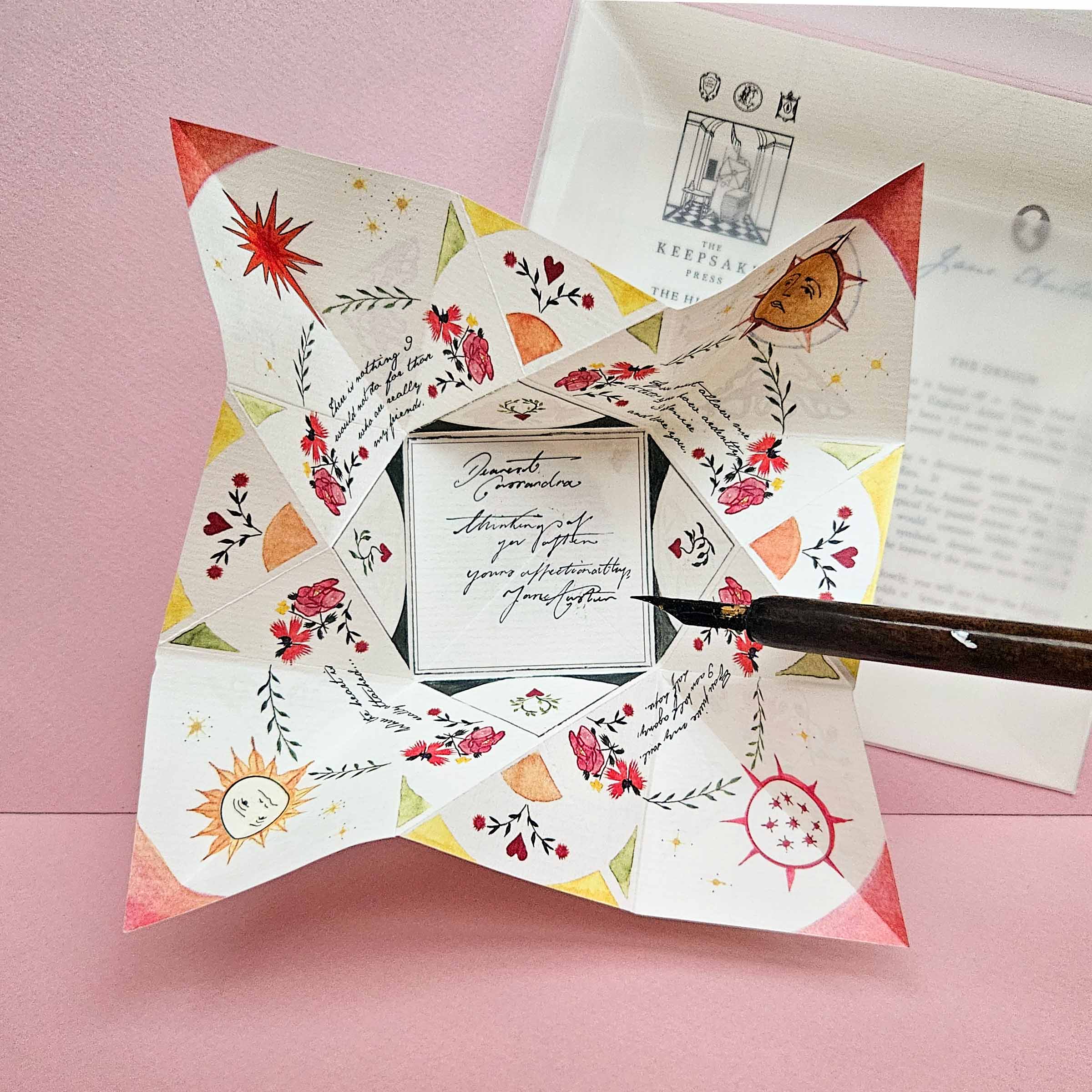 Decorative paper with floral patterns and a fountain pen on a pink background