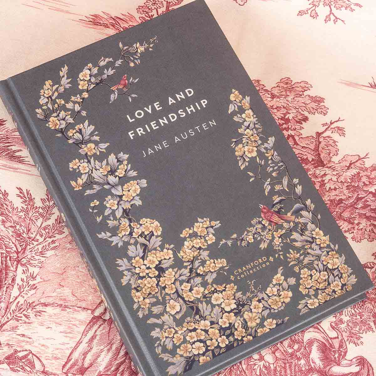 'Love and Friendship' main cover decorated in blossoming yellow flowers and songbirds. Cover background is a charcoal with a hint of blue.