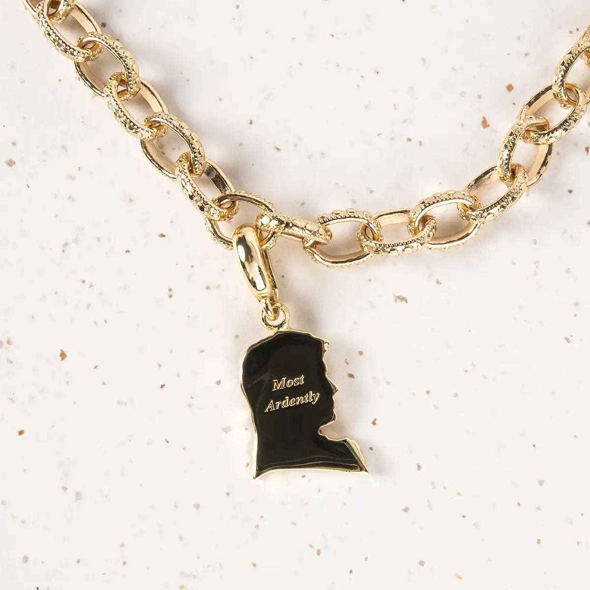 Gold chain bracelet with a Mr Darcy silhouette charm engraved with 'Most Ardently' 