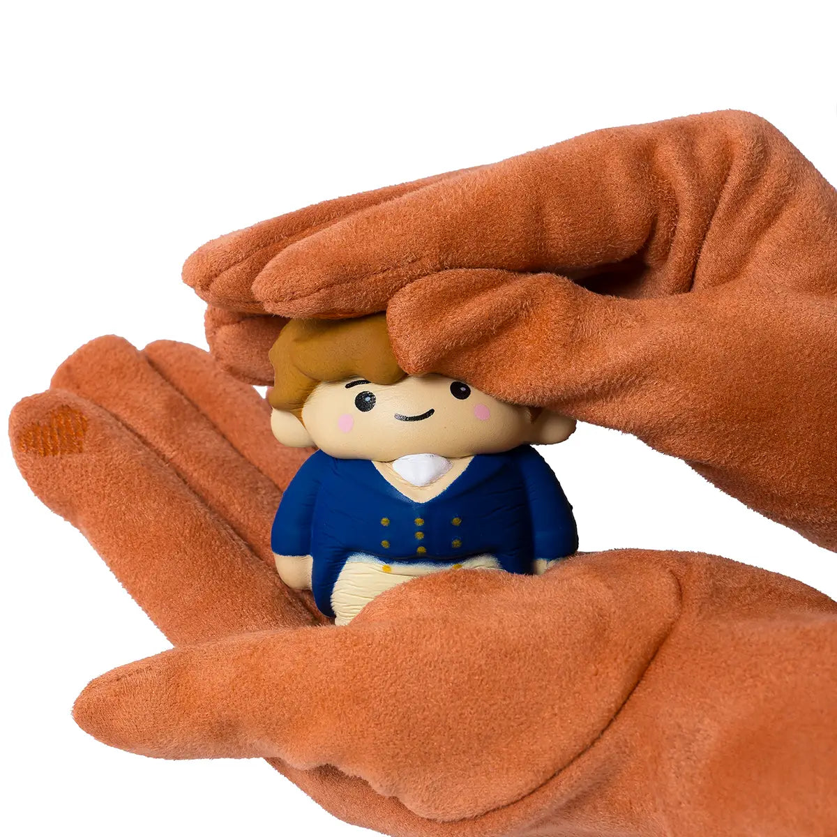 Mr. Darcy Squishi Pal being squashed by hands in burnt orange regency gloves againsta white background