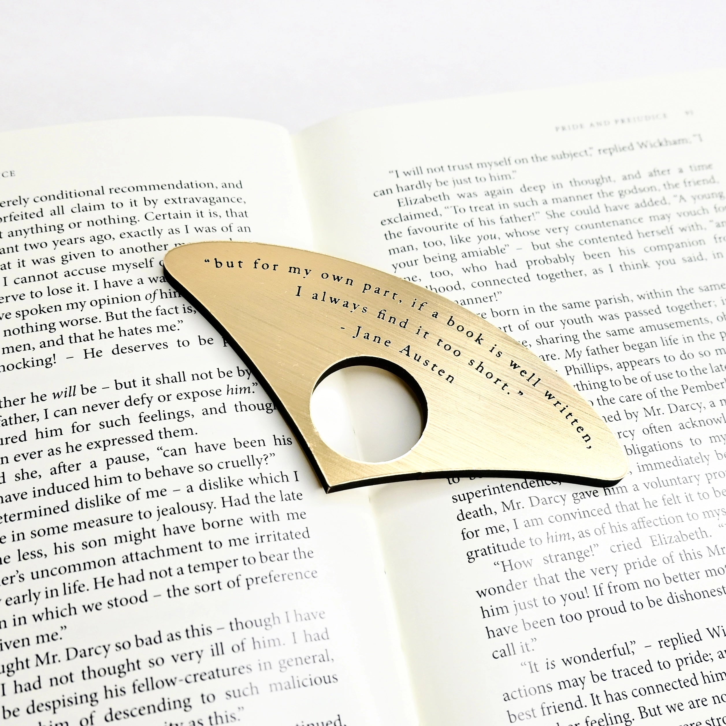 An open book and A gold book page spreader featuring a black engraved quote 'but for my own part, if a book is well written, I always find it too short' Jane Austen.