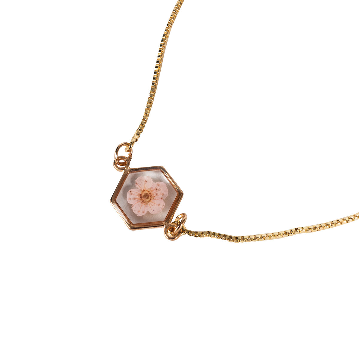 Close up of a Pastel Pink Flower Bracelet with gold chain, hexagonal frame featring a pressed pastel pink flower