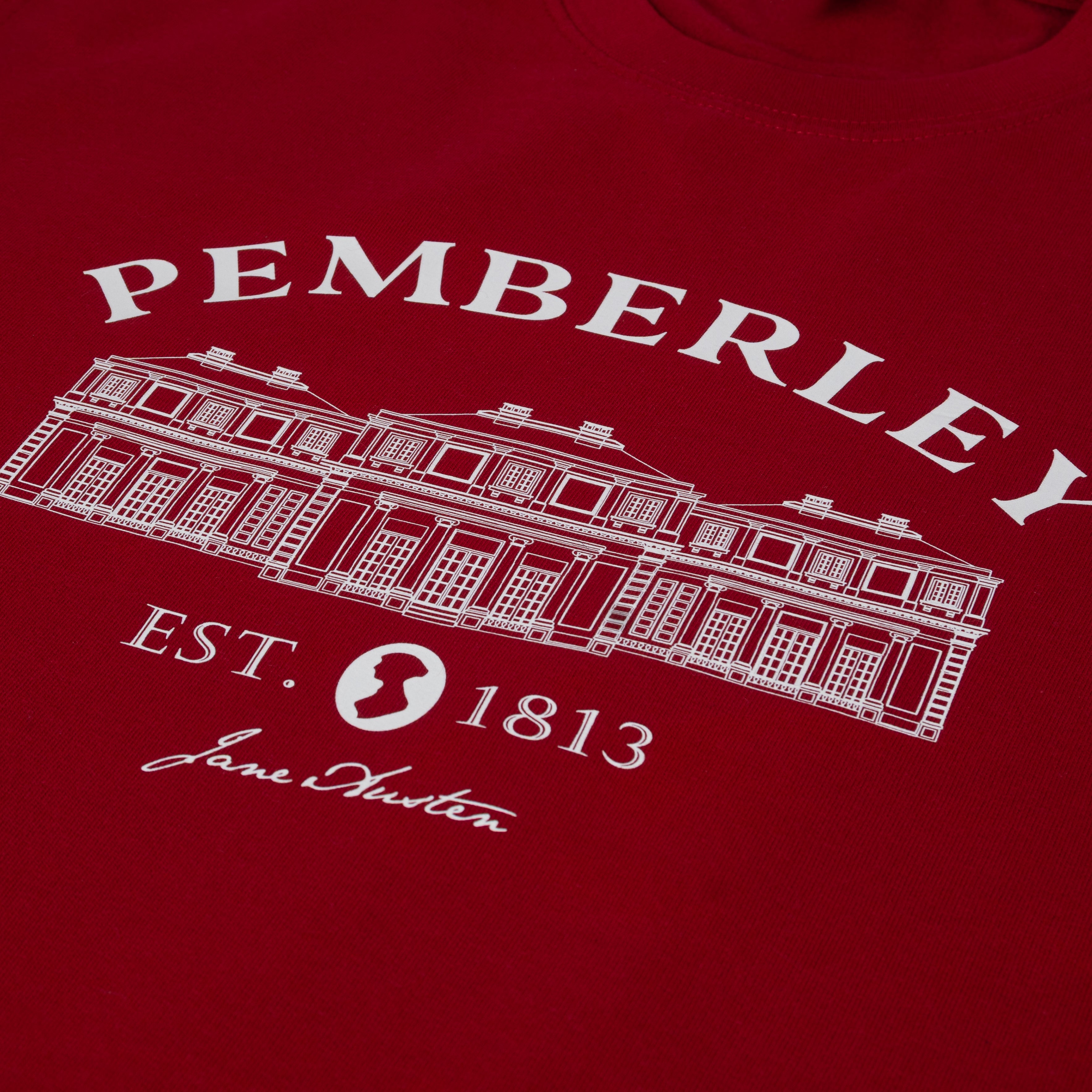 close up of Pemberley Est. 1813 text and image of Pemberley manor on a red sweater
