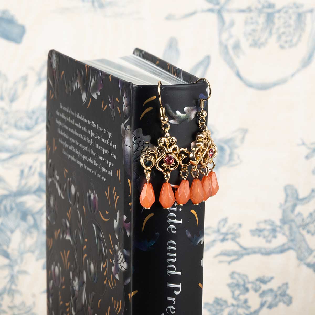 Gold-enamelled Regency Coral Drop Earrings with three coral droplets and a red gemstone in the centre of each earring.