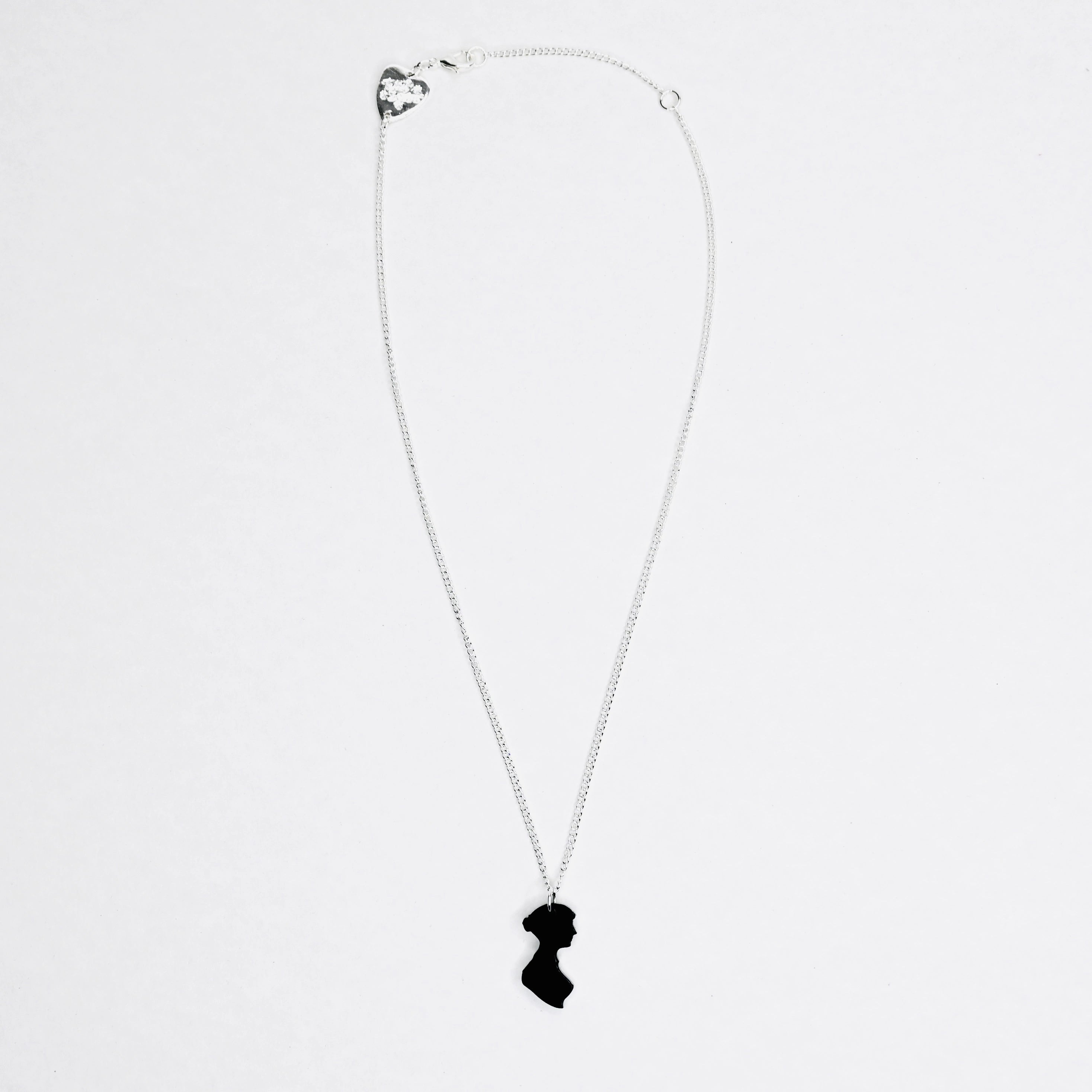 Full view of a Black acrylic necklace on silver chain in the shape of Jane Austen's silhouette