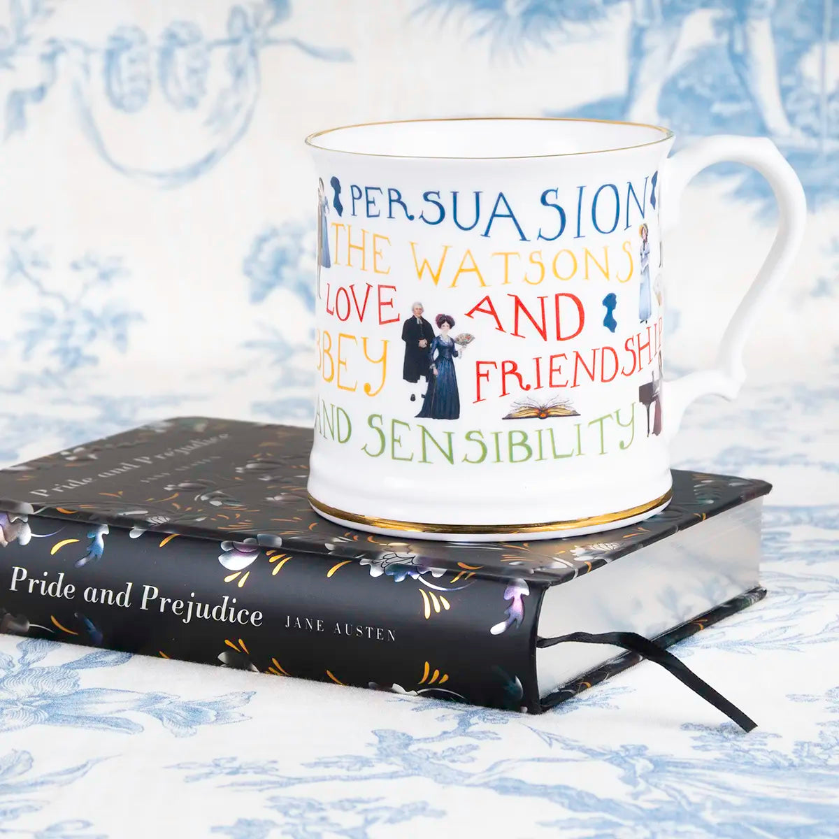 Jane Austen themed mug with gold trim on top of a copy of pride and prejudice