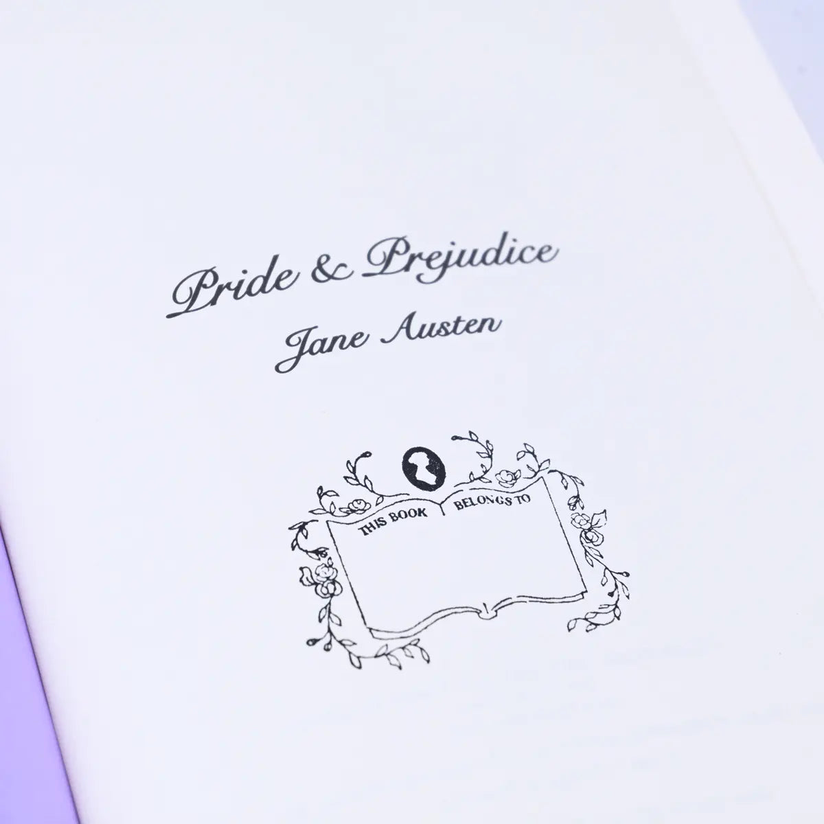 Stamp showing a Jane Austen logo, floral framing and text  "This book belongs to" on a Pride & Prejudice book page