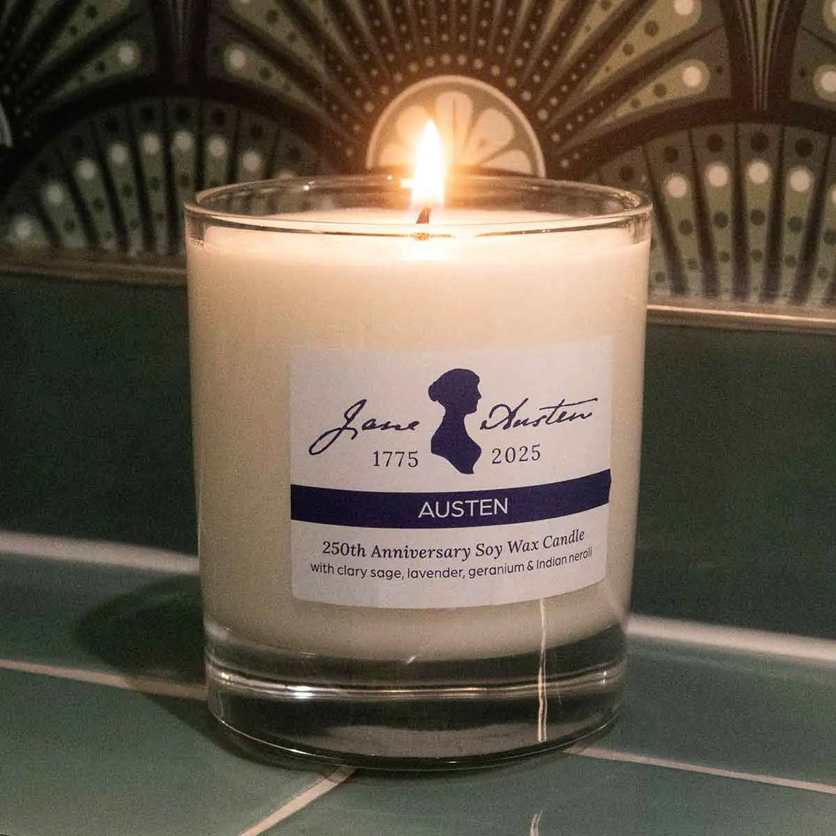 candle, lit, on tile surface, against green wallpaper