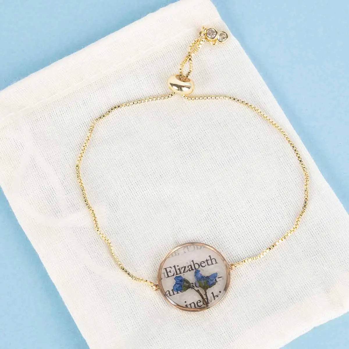 Jane Austen bookpage bracelet with two blue flowers and a gold chain