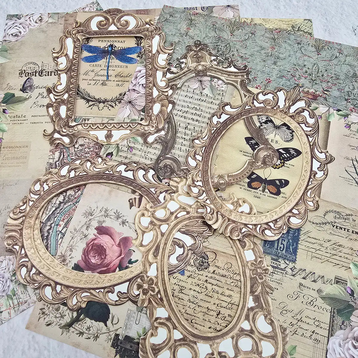 Decorative ornate frames made from paper with vintage-style illustrations on a textured surface