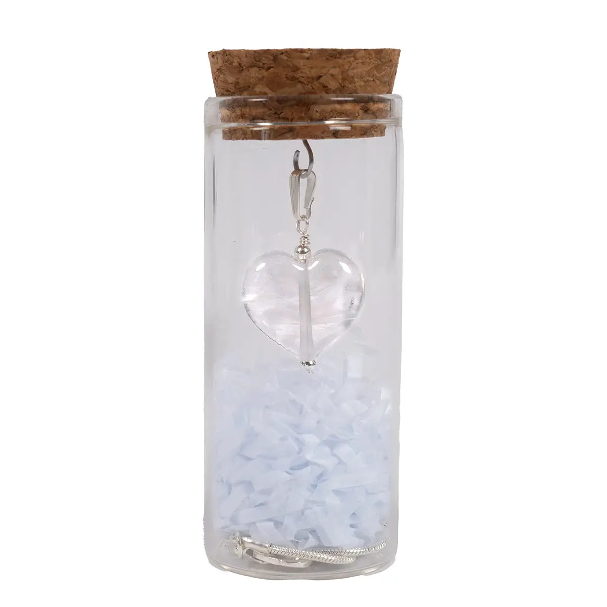 white glass heart pendant in a glass vial with cork, chain, and shredded tissue paper