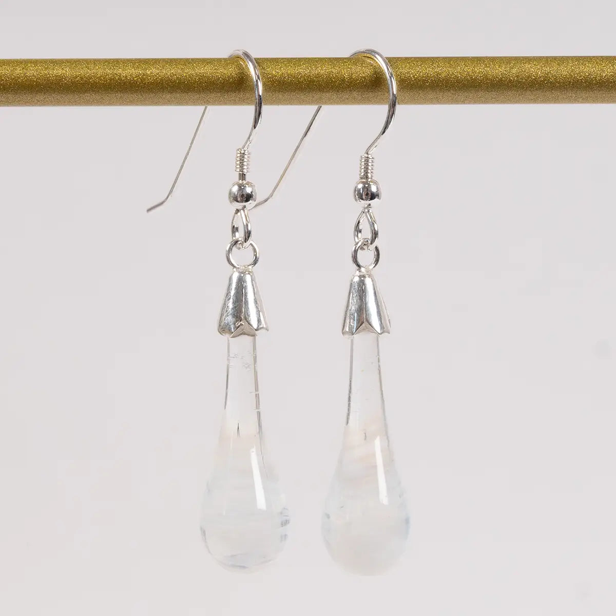 white glass drop earrings against a white background