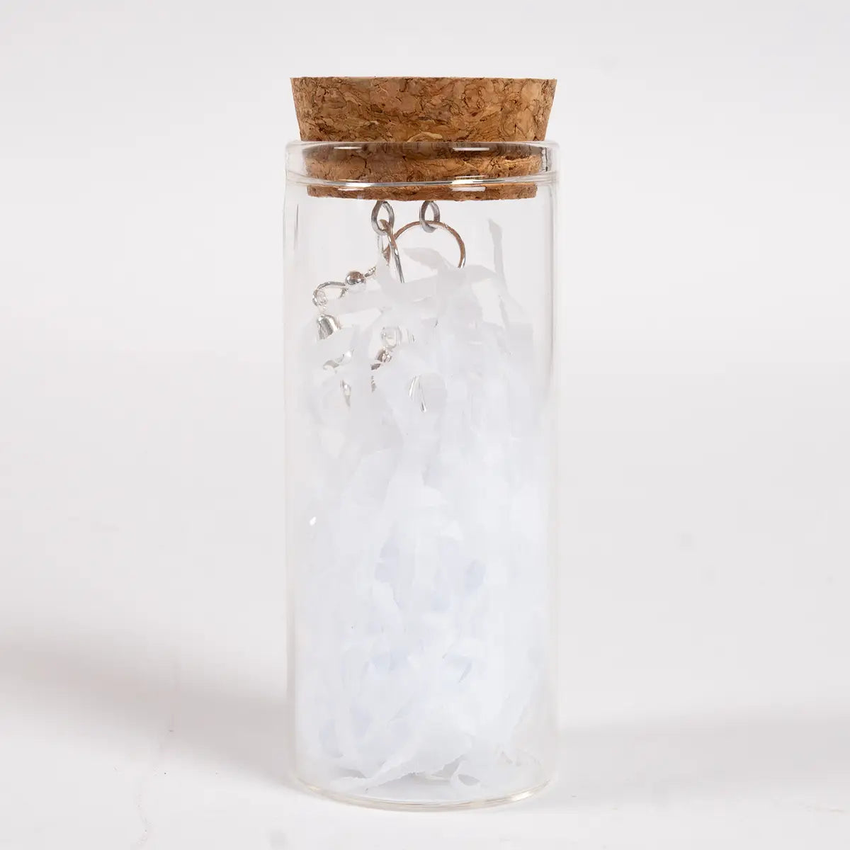 White glass dop earrings inside a glass tube with a cork and paper shreddings
