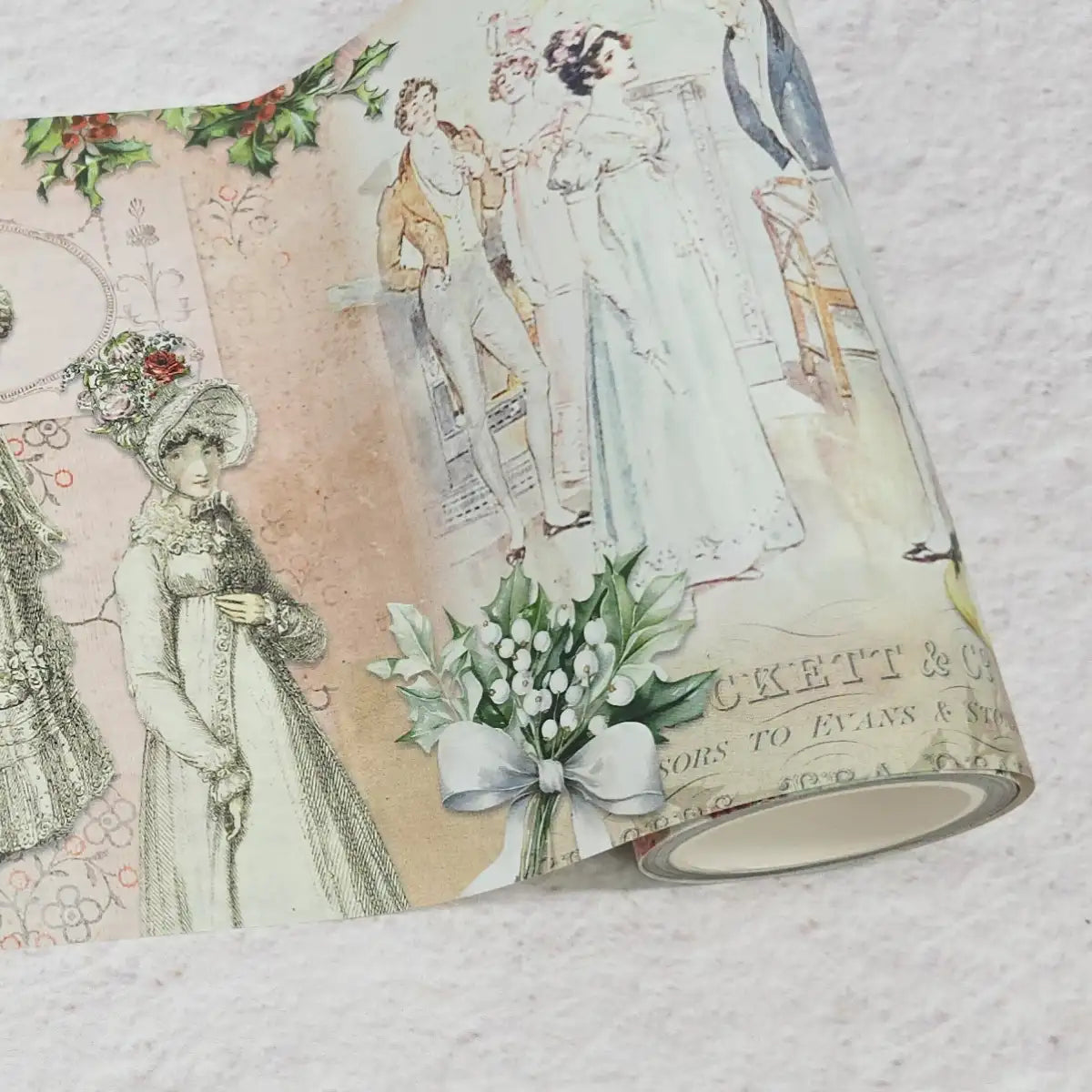 Decorative washi tape roll with vintage-style illustrations of people and flowers on a textured surface.