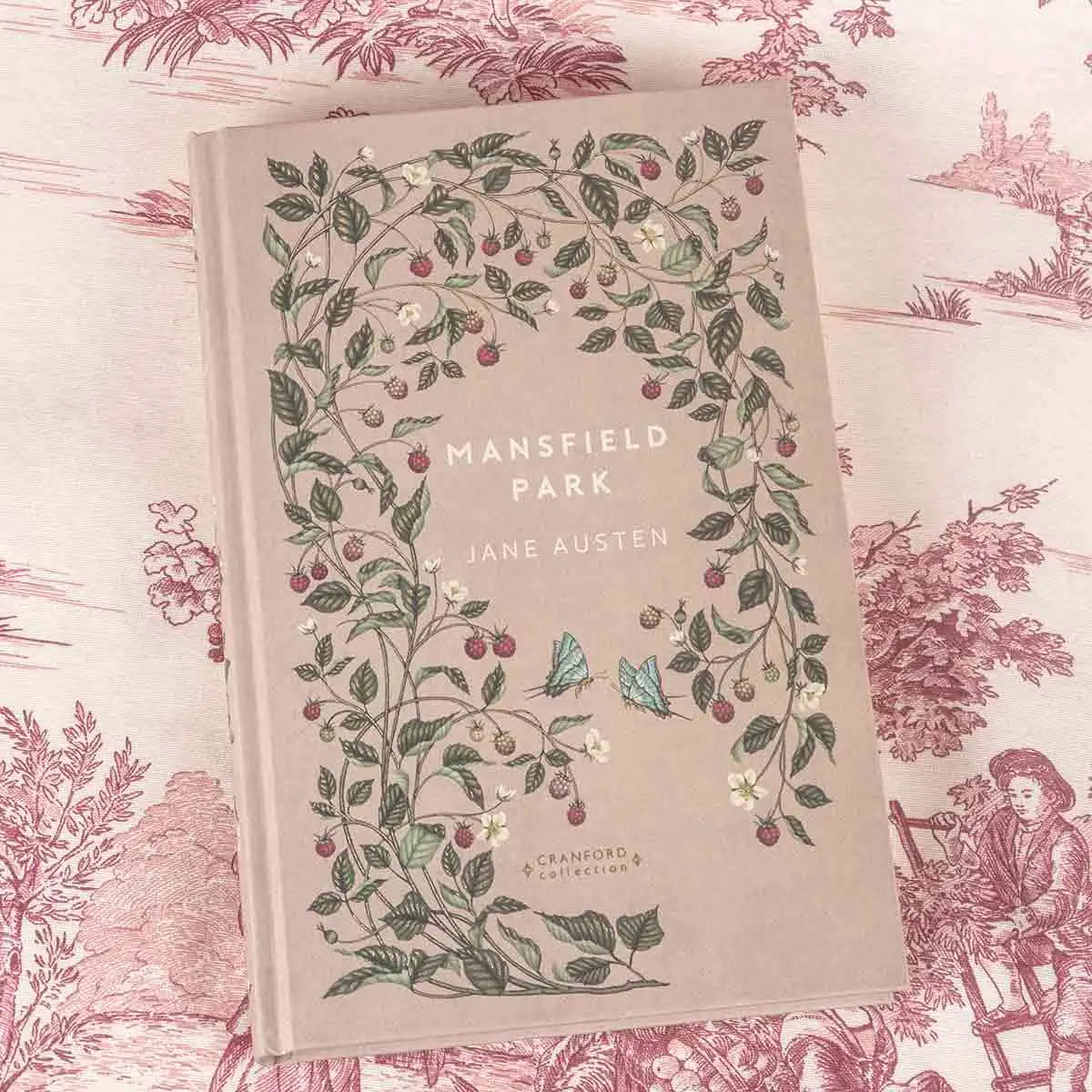 Front cover is beige with strawberry plants and leaves decorating the cover, alongside two blue butterflies