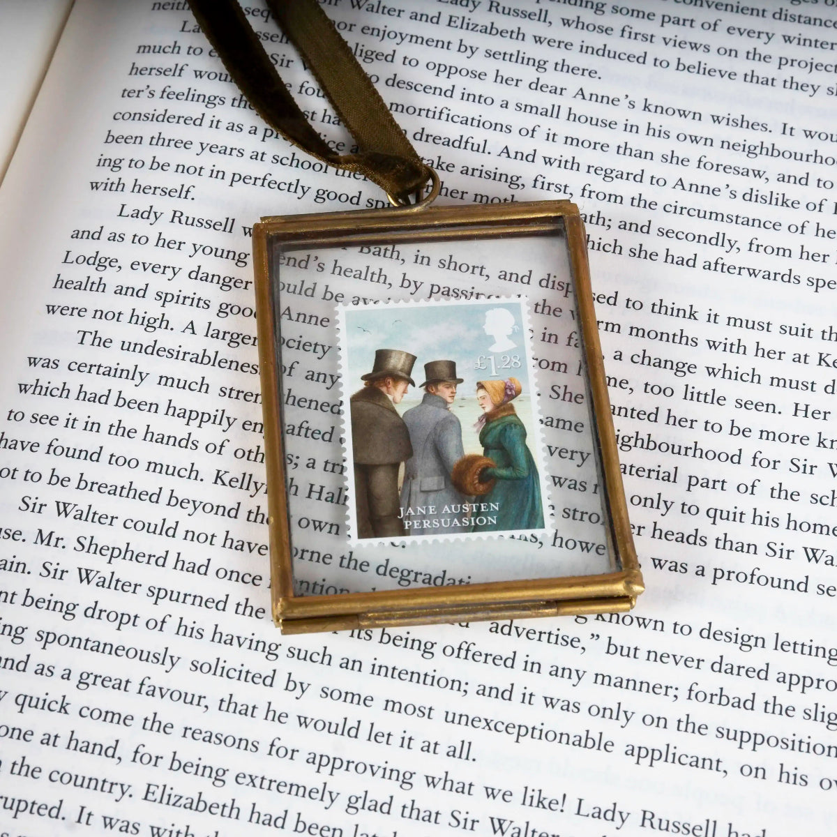 Gold-framed stamp of two people in regency clothing on a book page