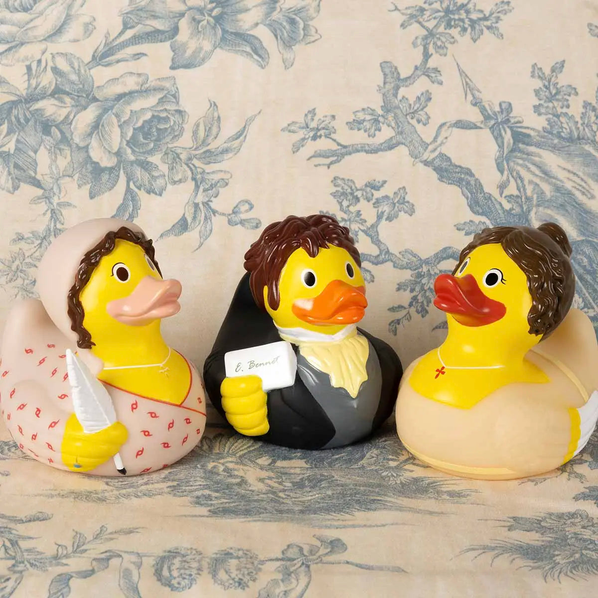 Elizabeth Bennet, Darcy, and Jane Austen ducks against a blue floral background.