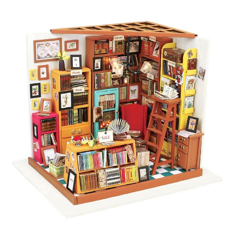 the miniature library is shown here on a white background to show the scene as a whole. It shows everything from the tiny red armchair to the broown wooden step ladder and the countless books that are around the walls